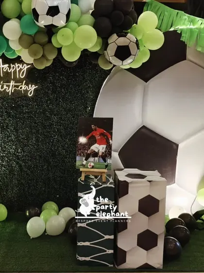 This view of the football party setup shows a personalized touch with a photo of the birthday boy in his football gear, making the decor unique to him.