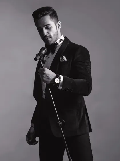 A black and white shot of the velvet tuxedo, emphasizing the timeless quality of the design. The play of light and shadow highlights the luxurious texture of the fabric.