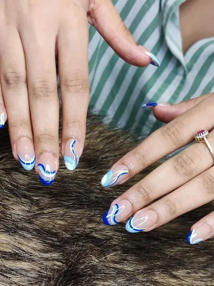 A full view of the blue and white wave design, showing how the patterns create a cohesive and eye-catching manicure.
