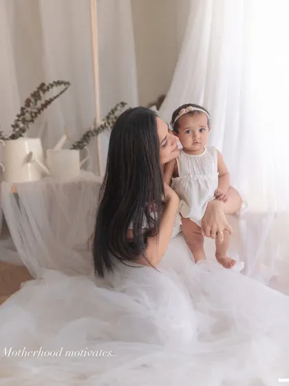 "Motherhood motivates." A mother shares a tender moment with her baby, a beautiful reminder of the strength and love that comes with being a parent.