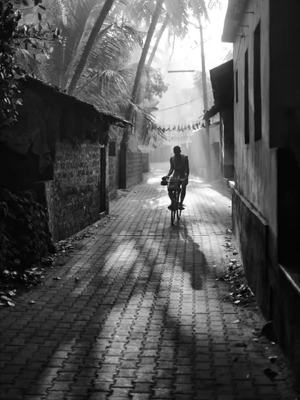 A black and white street scene from my first solo trip to Gokarna in 2012. I was documenting the simple life of the locals, like this man cycling through a sunlit alley.