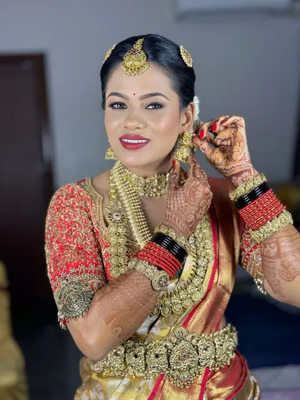 A candid moment of the bride adjusting her earring. Her makeup looks perfect from every angle.