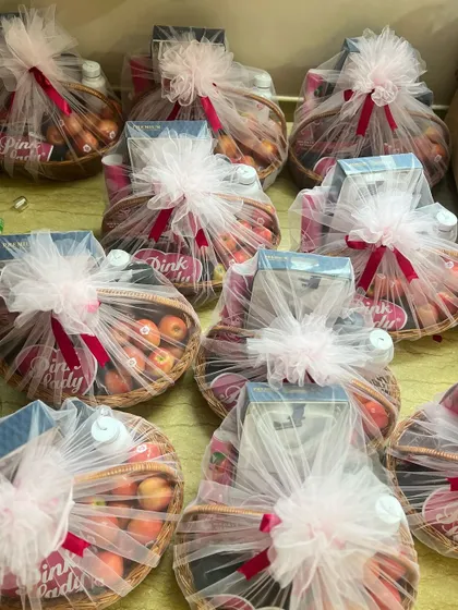An overhead view of multiple 'Pink Lady' gift baskets, all consistently wrapped and ready for dispatch.