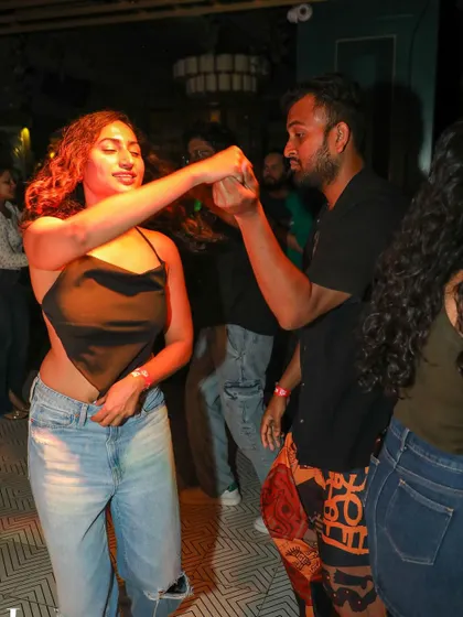 A stylish dancer leads her partner in a turn, both enjoying the music. Our socials are a great place to express your personal style.
