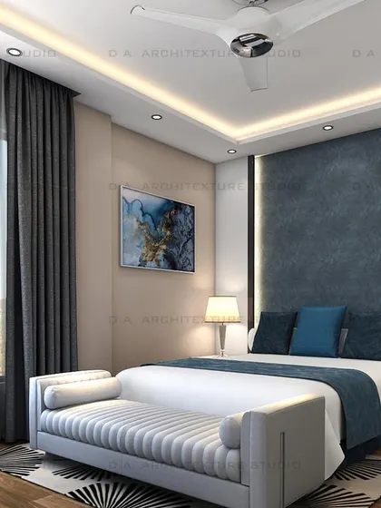 This bedroom design uses a deep blue fabric headboard to create a striking focal point, balanced by neutral walls and wooden flooring.
