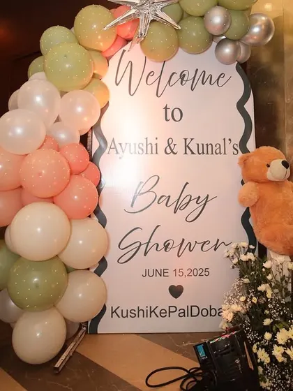The welcome setup for Ayushi & Kunal's baby shower, featuring a personalized sign, cute teddy bears, and a soft pastel balloon arrangement.
