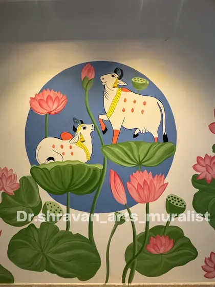 Pichwai elegance at its finest. This mural depicts a cow and calf resting on large lotus leaves, set against a calming blue circle. The composition is serene and spiritually uplifting.