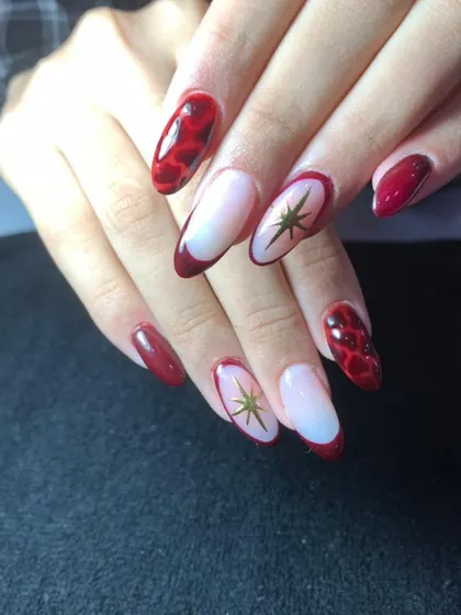 A bold red set with a mix of styles, including a snakeskin pattern, French tips, and gold star accents.