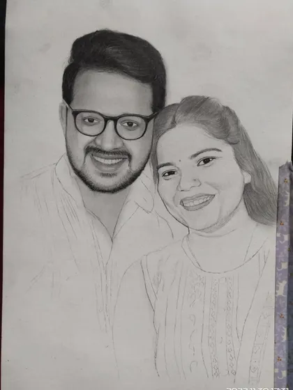Another progress shot of the couple's portrait, showing the gradual process of adding shading and detail to bring the drawing to life.