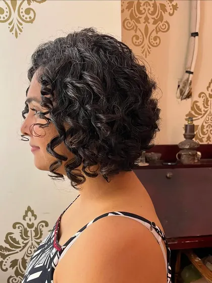The side profile of Maya's new curly bob, showing the spring and bounce in her curls.