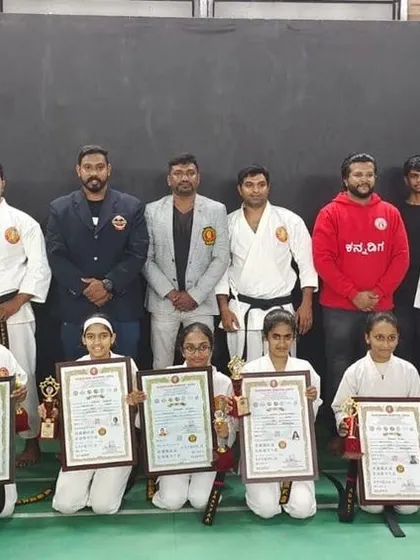 A group of our senior students after a successful tournament, holding their certificates and trophies. Their achievements reflect the high standard of our competitive karate program.