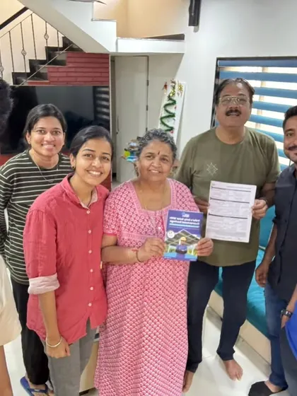 A family of all ages joins our team for a photo, holding their new solar agreement. It’s a collective decision for a sustainable future.