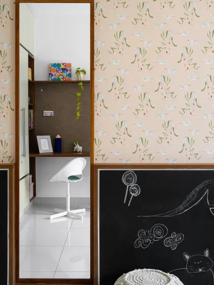 A full-length mirror and chalkboard wall add function and fun to the 'Poorna' kids' room, framed by a beautiful, whimsical wallpaper.