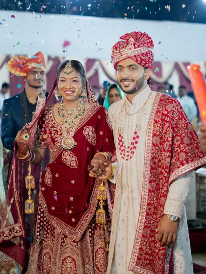 The bride and groom make their grand exit as a married couple, showered with confetti by their loved ones.