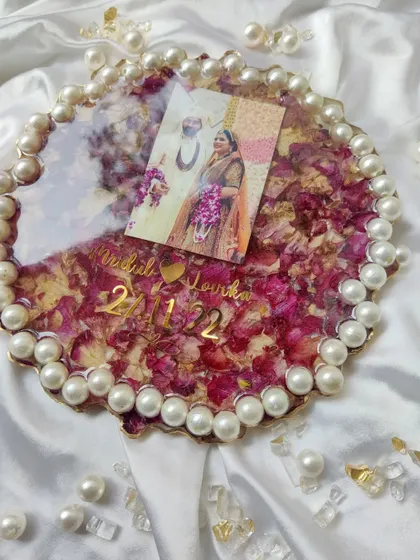 Another beautiful shot of the pearl-bordered varmala frame, surrounded by loose pearls, highlighting the elegance and craftsmanship of the piece.