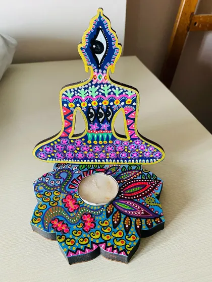 The back of a Buddha candle holder, showing that the intricate painting continues all the way around. I love the third eye detail on this one.
