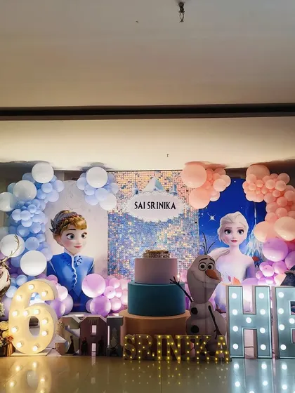 A centered shot of the Frozen stage, showing the shimmering backdrop and pastel balloon arches.