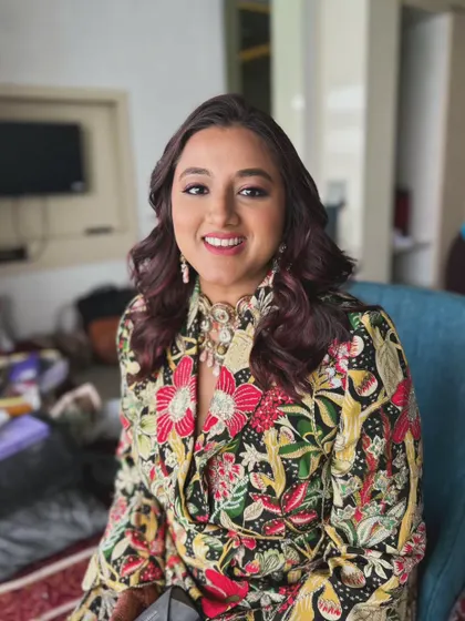 The client looks happy and ready to party. The glam makeup enhances her features and complements her colorful outfit.
