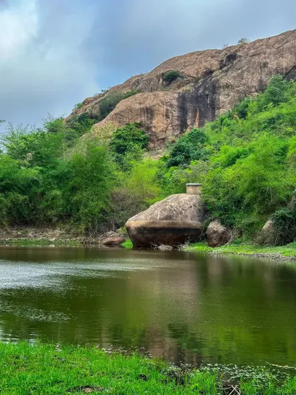 A tranquil lake at the base of the Bananthimari hills, a serene spot for relaxation before or after the trek.