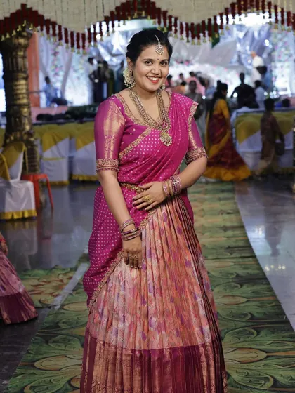 A photo of the mother in her elegant pink and purple langa voni, a perfect match to her daughter's outfit.