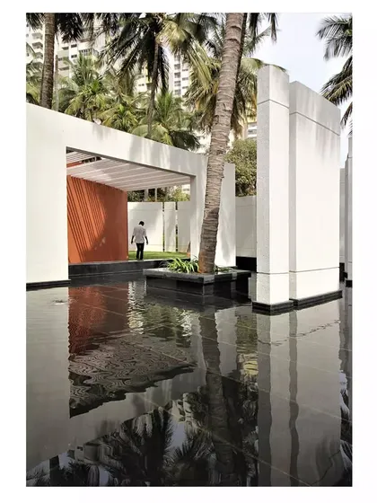 A reflective water feature at the Akriti Experience Centre mirrors the sky and the surrounding architecture, adding a sense of tranquility and depth to the space.