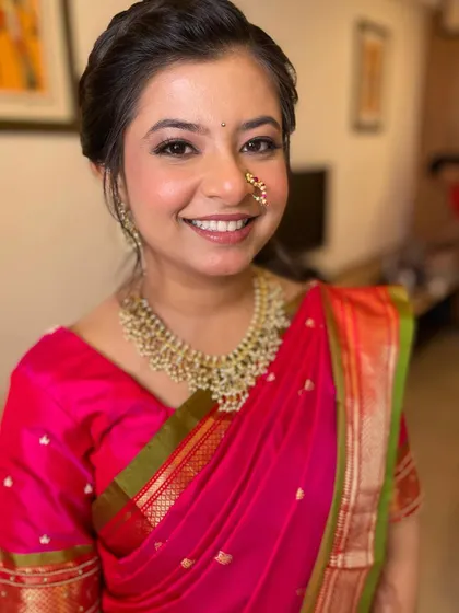 A straight-on shot showcasing the bride's flawless skin and bright smile. The makeup is subtle enough to let her natural beauty shine.