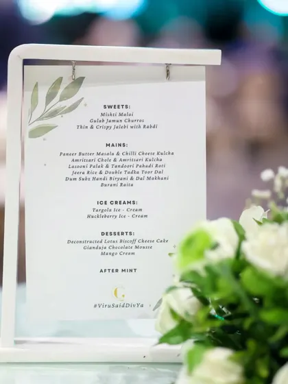 A custom menu elegantly displayed on a tabletop stand. We work with you to design every detail, including printed materials that align with your event's theme and our culinary offerings.