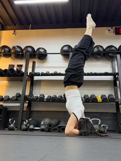 Headstand practice in the free weights corner of the gym at Fitness First.