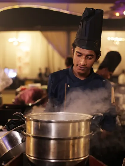 Steam billows from a multi-tiered steamer, a sign that delicious dim sum are moments away from being served. This is a common sight at our bustling Pan-Asian live stations.