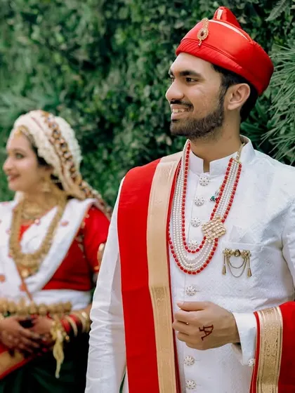 Another beautiful portrait of the Marathi couple, with the groom looking ahead while the bride stands softly in the background. It’s a serene and elegant composition.
