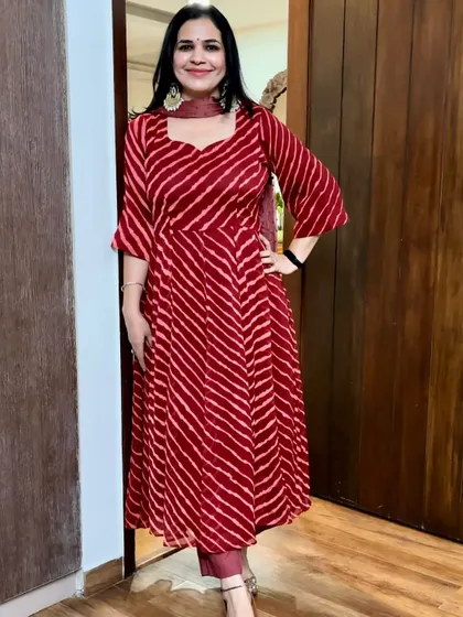 A beautiful red leheriya saree transformed into a flared Anarkali kurta. The vibrant pattern and color are perfect for festive wear.