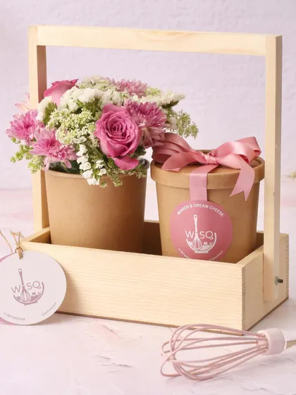 A delightful Mother's Day gift set. This charming wooden caddy holds one of our Mango & Cream Cheese dessert tubs and a matching bouquet of fresh pink flowers, combining two classic gifts into one.