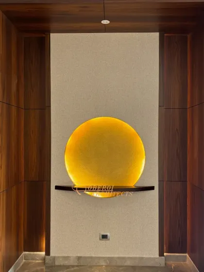 A close-up of the art niche, where a simple circular light fixture illuminates a small shelf, turning a small space into a point of interest.