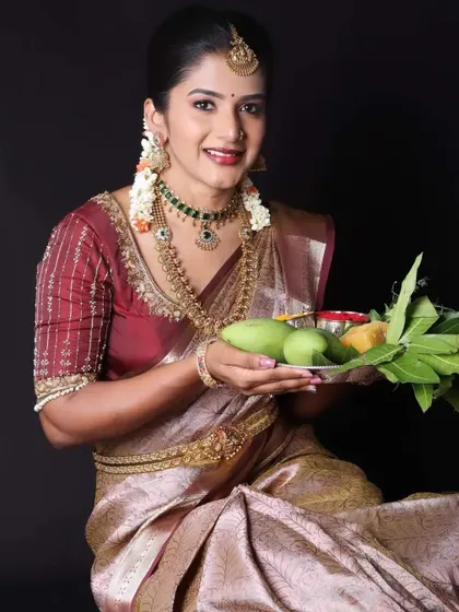 The model holding the traditional Ugadi platter, looking festive and elegant.