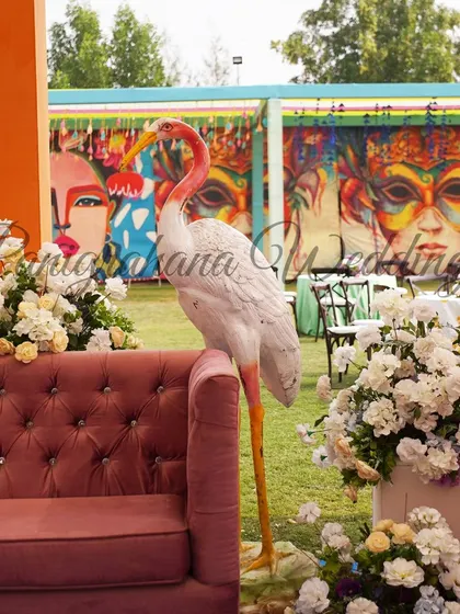 A close-up of the quirky decor, with a large flamingo prop next to a pink sofa, set against a graffiti-style backdrop.
