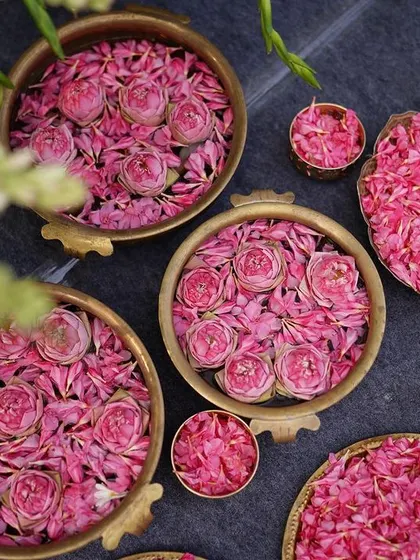 Bowls of fresh pink rose petals, ready for guests to shower the happy couple. Even the most practical items are presented in a way that is beautiful and fits the decor theme.
