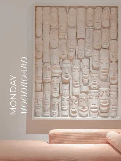 This unique wall art, composed of dozens of carved wooden masks painted in a uniform off-white, creates a stunning textural focal point. It's a perfect example of how we use art to add sculptural presence to a room.