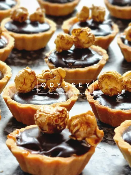 Our signature chocolate tarts topped with caramel popcorn. This combination of rich chocolate, buttery pastry, and crunchy popcorn is a unique and delightful treat.