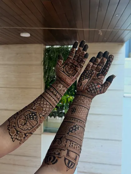 A full-arm bridal design with a mix of personalized story elements and traditional patterns, shown from the back of the hands.