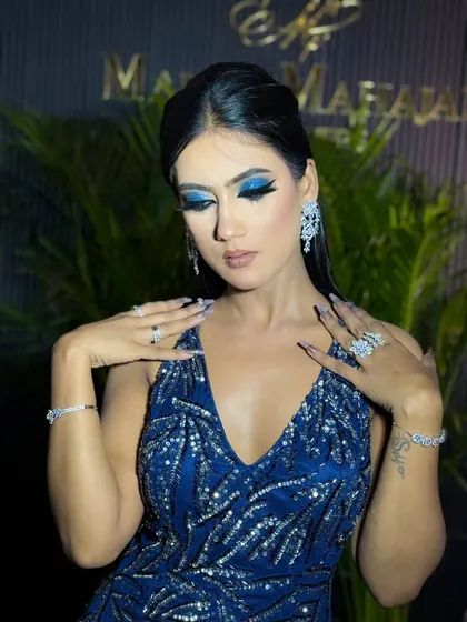 A glamorous pose with the model's hands framing her face, highlighting her stunning jewelry and makeup.