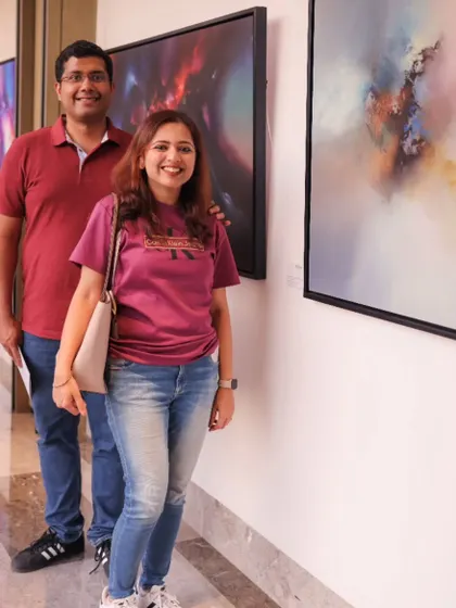 A couple enjoying the 'Mystic Mirage' exhibition, taking in the large-scale abstract canvases.