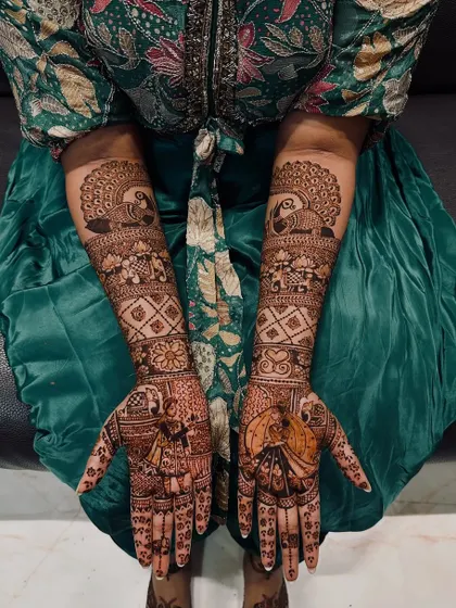 This bridal design features charming parrot figures on the palms, a symbol of love and passion. The upper arms are adorned with majestic peacocks, creating a beautiful aviary theme.