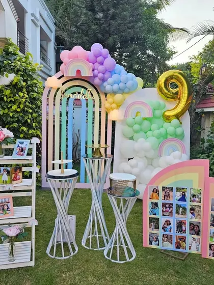 Samriddhi's 9th birthday was a dreamy pastel rainbow party. This outdoor setup includes rainbow-arched backdrops, cloud-like balloon clusters, and a photo milestone board, creating a whimsical and personal celebration.