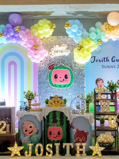 A close-up of the Cocomelon birthday setup, showing the sequin backdrop and themed cake stands.