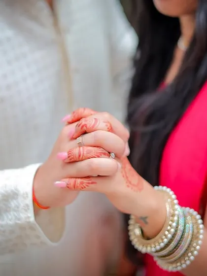 A close-up shot focusing on the couple holding hands, a simple yet powerful symbol of their engagement.