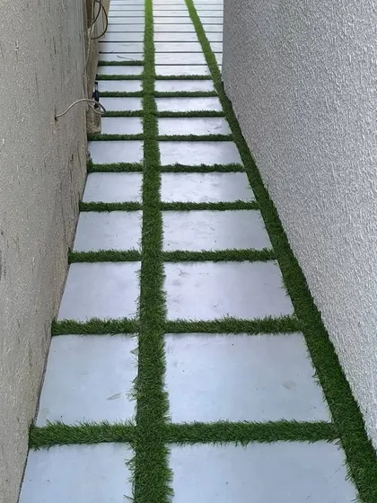 This project shows a creative use of artificial grass in a narrow side yard. I installed synthetic turf between large concrete pavers to create a unique and visually interesting walkway that is both functional and green.