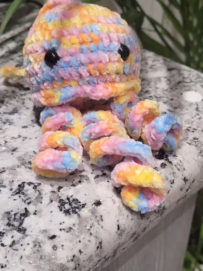 My first baby jellyfish sitting on a countertop, showing off its cute, curly tentacles. Each one is handmade and has its own little personality.