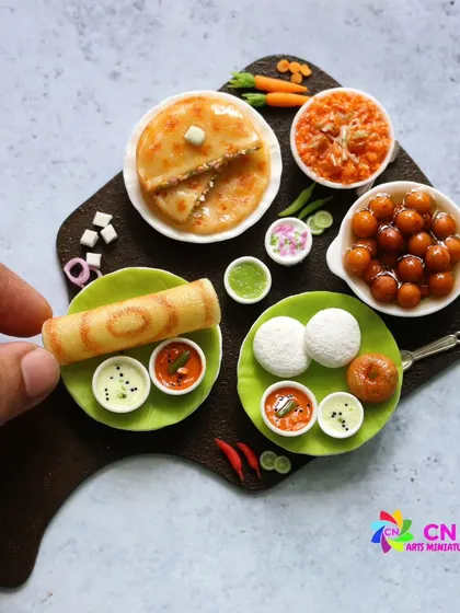 A beautiful platter showcasing a variety of South Indian dishes, including dosa, idli, vada, and gulab jamun.