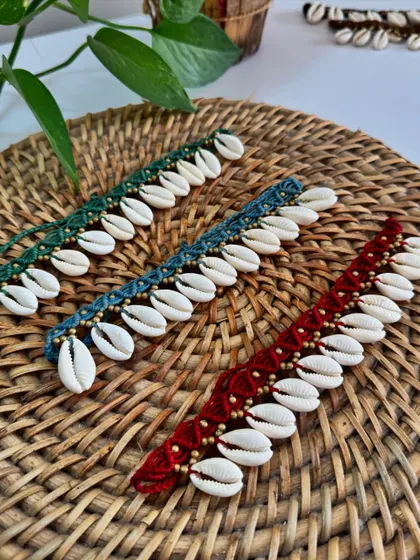 These macrame anklets with cowrie shells and gold beads are perfect for a beach vacation. They come in several rich colors like green, blue, and red.