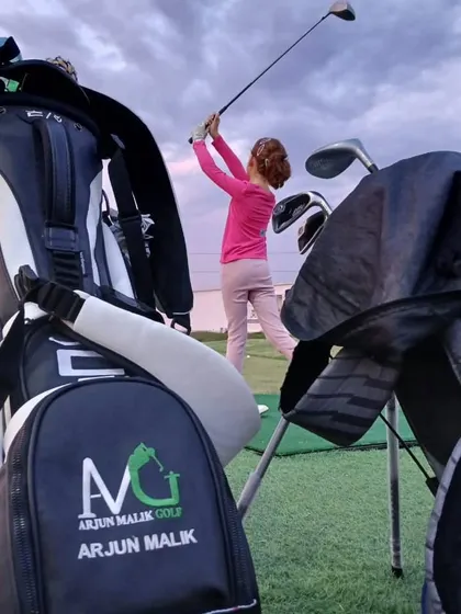 A young golfer perfects her swing against the evening sky. My academy provides the ideal setting for dedicated practice, helping aspiring players hone their skills.